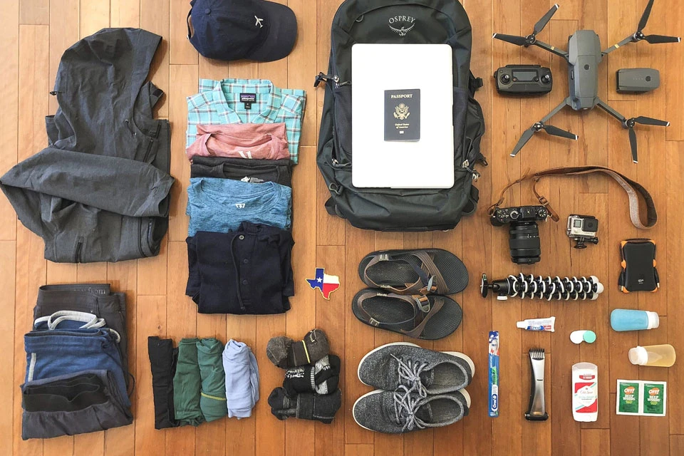 Safari packing list essentials laid out neatly on a wooden floor.